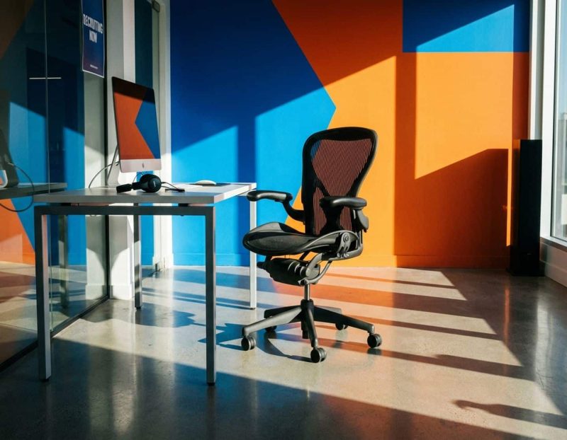 lege ergonomische bureaustoel met headset bij modern bureau, symboliseert vacante klantenservice posities in strak kantoor