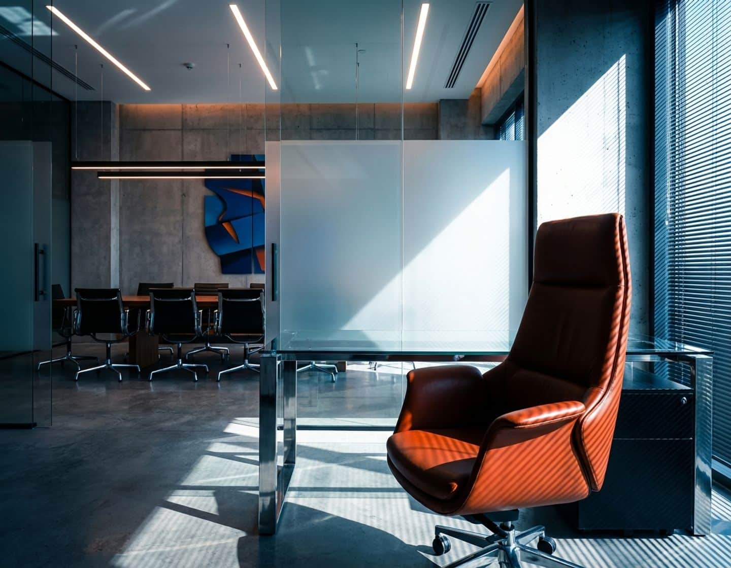 lege directiestoel achter modern bureau in minimalistisch kantoor met dramatische blauwe en oranje verlichting